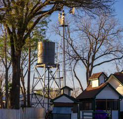 water tower next to a windmill at an abandoned farm house.