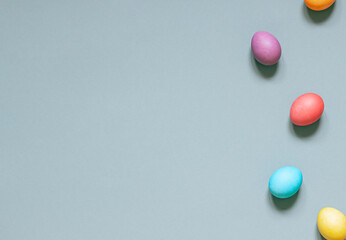 Colorful painted Easter eggs on the gray background. Top view. Copy space	