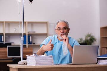 Old male employee in blood transfusion concept