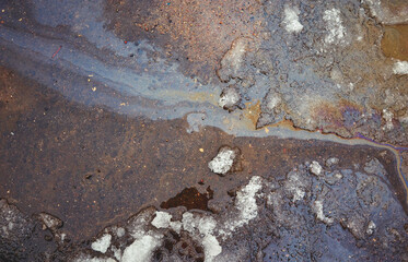 iridescent spot of gasoline on pavement as Texture or Background