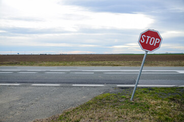 Red stop sign on the road. Traffic sign in countryside. Street.