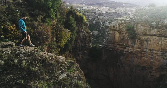 Aerial view of hiker walk towards cliff mountain edge in Lebanon, forward, day