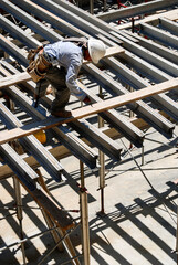 Construction worker building I-beam support frame
