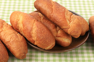 Delicious breads next to ears of wheat on a wooden board. Bakery products.