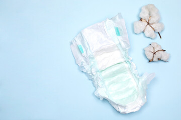 baby care pad with cotton flowers over blue background