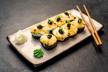 baked sushi rolls on a stone background