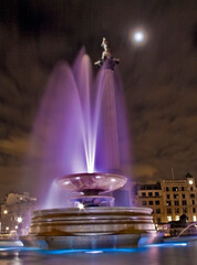 The Trafalgar Square fountain and Nelson column in London at night 