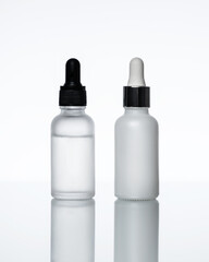 Bottles of serum on a light background. Moisturizer, vitamin C, hyaluronic acid.