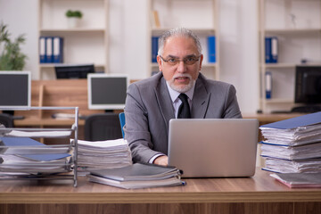 Old male employee unhappy with excessive work in the office