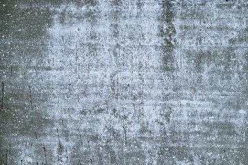 Background texture of an old gray concrete wall. Traces of old white paint.
