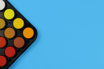 Set of watercolor paints with a brush close up