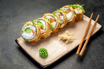 baked sushi rolls on a stone background