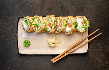 baked sushi rolls on a stone background