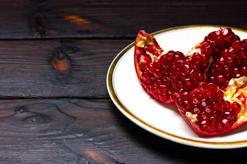 Red ripe pomegranate fruit on a white plate. Still life of pomegranate fruit.