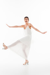 Obraz premium full length view of cheerful bride looking at camera while dancing on white