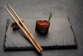 Gunkan maki with salmon caviar (Ikura) on a stone background © александр таланцев