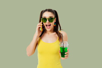 Excited young woman wearing summer outfit and colored sunglasses smiling