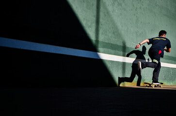 Firefighter Skating wearing a blue uniform with his shadow on a green wall