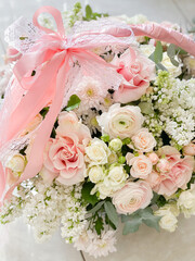 A basket with delicate colors. Roses, ranunculi, lilacs. Spring bouquet as a gift to your beloved. Beautiful romantic floral arrangement.
