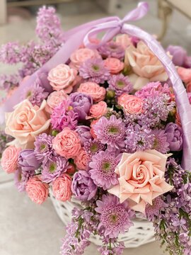 A big beautiful basket with delicate pink flowers. Chrysanthemum, roses, lilacs, tulips, hyacinths. A romantic gift for the holiday. Background image of a flower shop