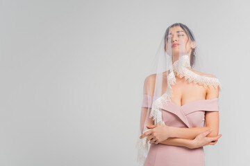 Fototapeta premium sensual woman in elegant dress and veil posing isolated on grey