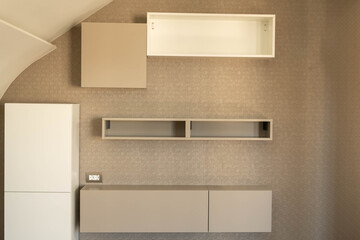 Hanging cabinets and shelves in the interior of a residential building in different shades of gray.
