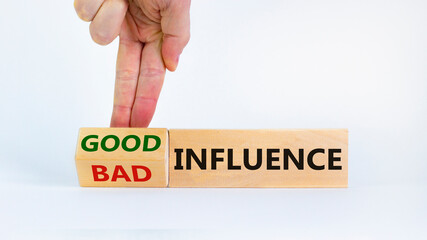 Good or bad influence symbol. Businessman turns cubes and changed words 'bad influence' to 'good influence'. Beautiful white background. Copy space. Business, good or bad influence concept.