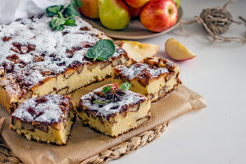 Homemade apple pie, sprinkled with powdered sugar and cut into slices. Charlotte pie with apples