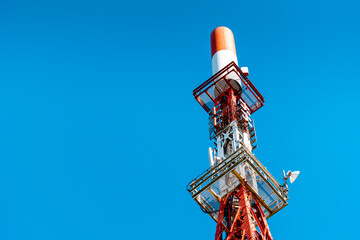 A tv broadcast tower in a blue sky