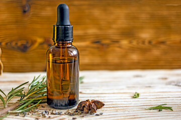 Cosmetic dark bottle with a pipette  dropper on a wooden background 