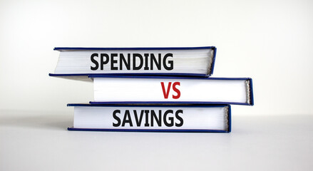 Spending vs savings strategy symbol. Books with words 'Spending vs savings'. Beautiful white background, copy space. Business, spending vs savings strategy concept.