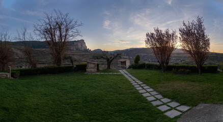 Jardín con barbacoa de un monasterio en plena naturaleza en atardecer colores vivos en el cielo