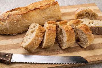 Traditional homemade french baguette bread with slices over wooden board