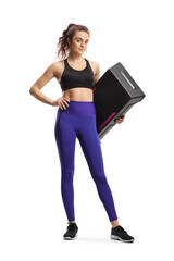 Full length portrait of a young woman in sportswear holding a step aerobic platform