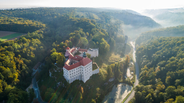 Limestone cliff Pieskowa Skala near Krakow, Poland, with isolated rock "Maczuga Herkuklesa" Hercules's mace
(Hercules cudgel or bludgeon) and historic Renaissance castle in morning fog in fall. Aerial