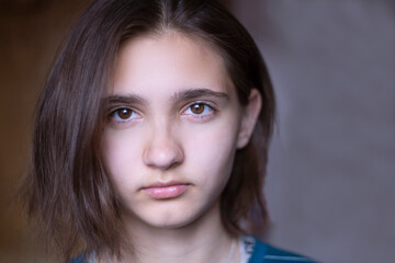 Naklejka premium Close-up of the face of a beautiful young brunette girl with dark brown eyes. Bob haircut, short hair.