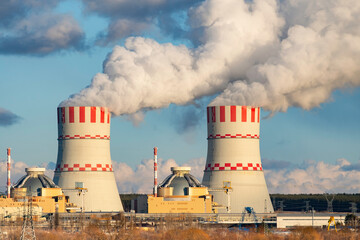 Cooling tower with steam clouds on Atomic nuclear power station. Industrial zone of nuclear with...