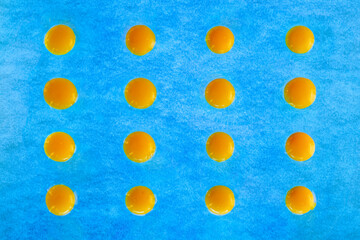 Pattern of egg yolks on blue textured background.
