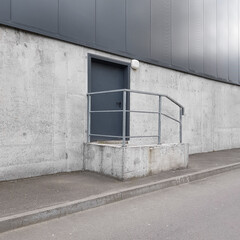 door on the facade, concrete wall of the building, technical or fire exit, loading area