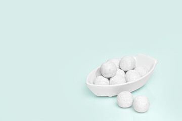 White round candies in a white ceramic vase. Blue background. Place for your text. High quality photo