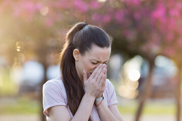 Woman sneezing because of spring pollen allergy
