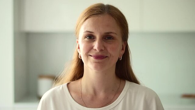 Healthy woman stand at modern kitchen interior and smile while looking at camera Spbd. 30s female