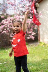 Portrait of happy little kid. Cute baby with Turkish flag t-shirt. Toddler hold Turkish flag in hand. Patriotic holiday. Adorable child celebrates national holidays. Copy space for text.