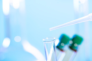 Chemical test tube and pipette close up on blue background