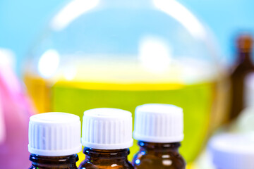 A set of flasks with chemical reagents on the background of a large glass flask with a yellow...