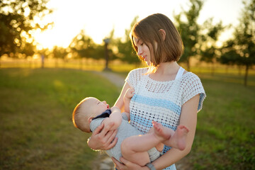 Cute big sister admiring her baby brother. Adorable teenage girl holding her new baby boy brother....