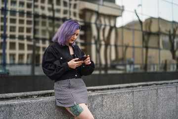 Chica con pelo morado interactuando con el smartphone y con la lluvia