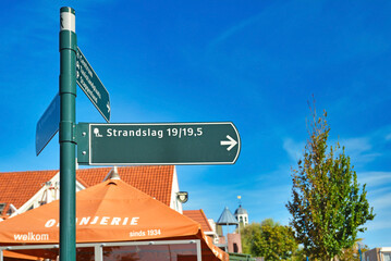 De Koog, Texel, Netherlands: Road sign leading to holiday park called 'Strandslag' in front of blue sky