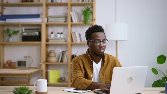 African office worker male clerk typing on computer Spbas. Concentrated serious man searches info