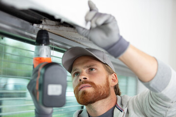 service man installing window with drill